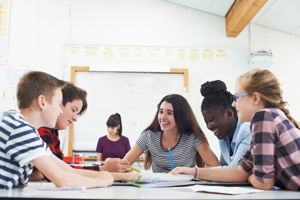 Group,Of,Teenage,Students,Collaborating,On,Project,In,Classroom